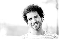 Man with curly hairstyle smiling in urban background